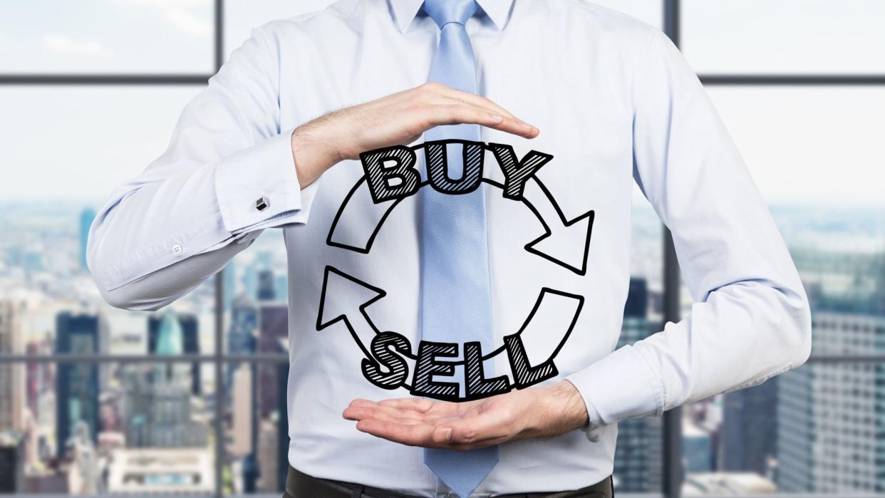 Businessman is holding a trading concept in his hands.
