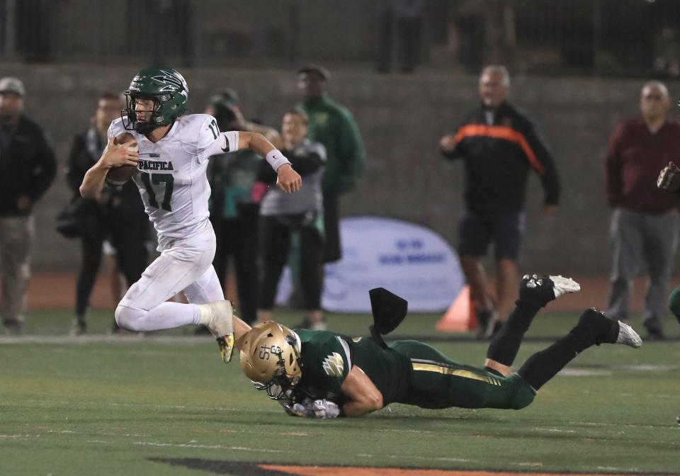 Pacifica quarterback Tagg Harrison is tripped up by St. Bonaventure's Jared Barlow late in the fourth quarter of the nonleague showdown at Ventura College on Friday, Aug. 26, 2022. St. Bonaventure rallied for a 46-41 win.