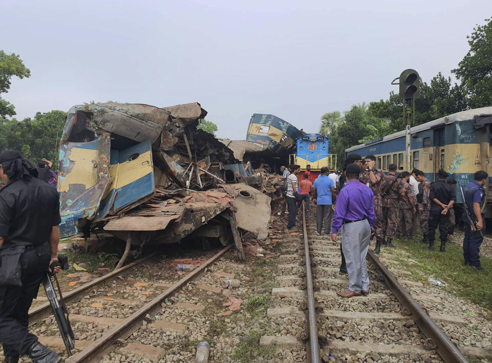 People gather near badly damages coaches after two speeding trains collided in in Brahmanbaria district, 82 kilometers (51 miles) east of the capital, Dhaka, Bangladesh, Tuesday, Nov.12, 2019. More than a dozen people were killed and scores were injured. (AP Photo)