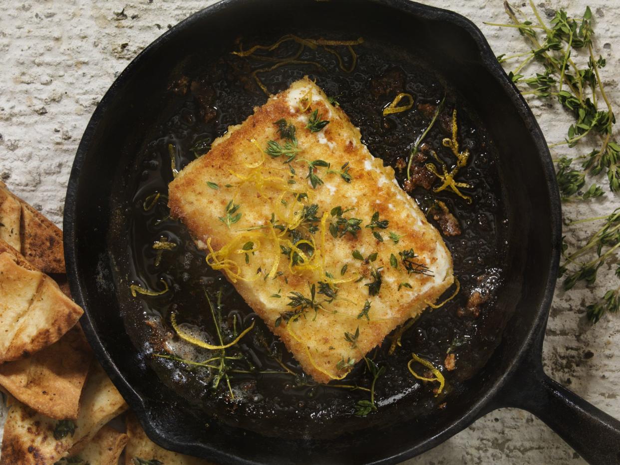 Breaded, Pan Fried Feta Cheese with Lemon Zest, Cracked Black Pepper and Thyme also known as Saganaki