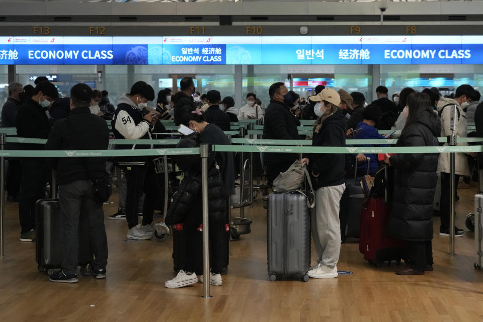 Passengers wait in line to board a plane to China at the Incheon International Airport in Incheon, South Korea, Tuesday, Jan. 10, 2023. China suspended visas Tuesday for South Koreans to come to the country for tourism or business in apparent retaliation for COVID-19 testing requirements on Chinese travelers. (AP Photo/Ahn Young-joon)