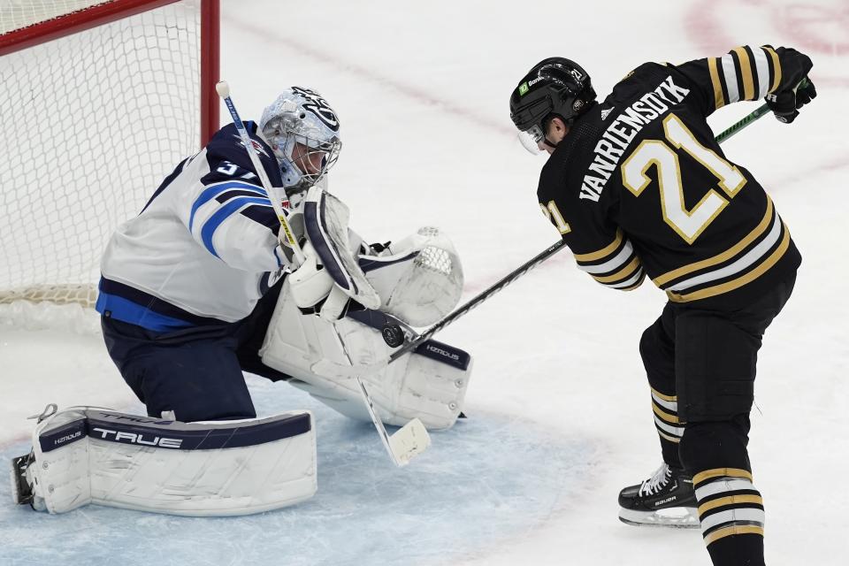Winnipeg Jets' Connor Hellebuyck (37) blocks a shot by Boston Bruins' James van Riemsdyk (21) during the second period of an NHL hockey game, Monday, Jan. 22, 2024, in Boston. (AP Photo/Michael Dwyer)