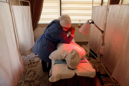 Gulgine Idris, an Uighur reflexologist, treats a patient at a health centre in Istanbul, Turkey, March 19, 2019. REUTERS/Murad Sezer