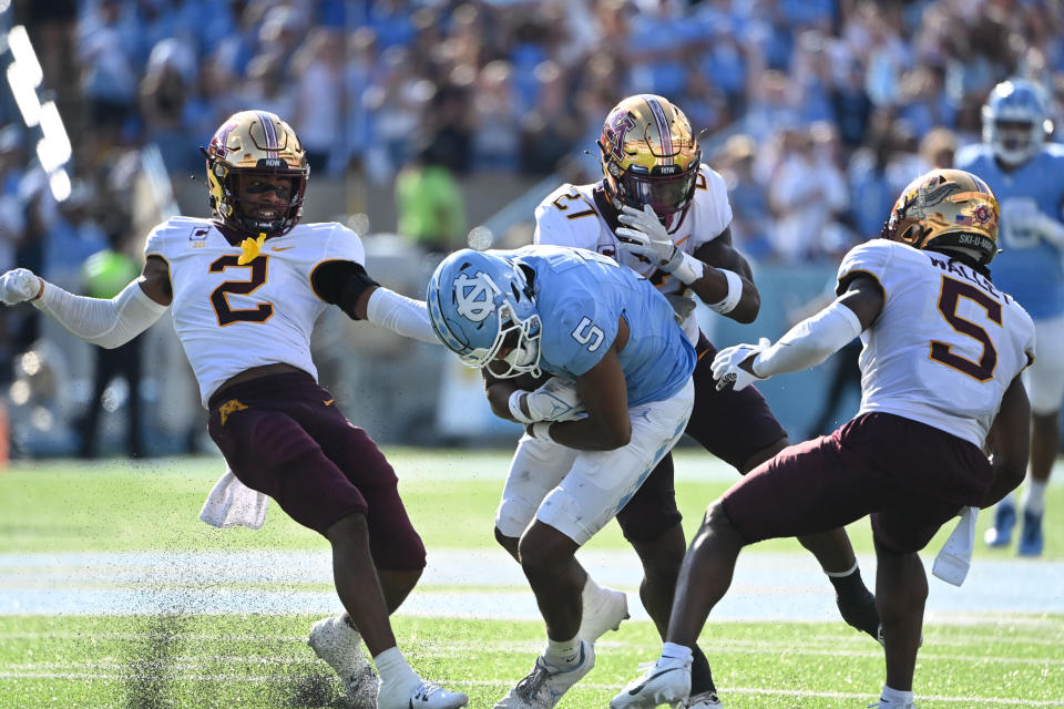 Sep 16, 2023; Chapel Hill, North Carolina, USA; North Carolina Tar Heels wide receiver J.J. Jones (5) catches the ball as Minnesota Golden Gophers defensive backs Tre’Von Jones (2) and Tyler Nubin (27) and Justin Walley (5) defend in the second quarter at Kenan Memorial Stadium. Mandatory Credit: Bob Donnan-USA TODAY Sports