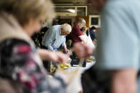 People pack groceries in their shopping caddies and bags at a food distribution center at the Catholic St. William Church in Berlin, Germany, Wednesday, May 31, 2023. German inflation eased to 6.1 % in May following several months of declines, even as Europe’s biggest economy registered another painful increase in food prices of nearly 15%. The Federal Statistical Office said Thursday that preliminary figures show that the annual inflation rate was lower than the 7.2 % registered in April. (AP Photo/Markus Schreiber)