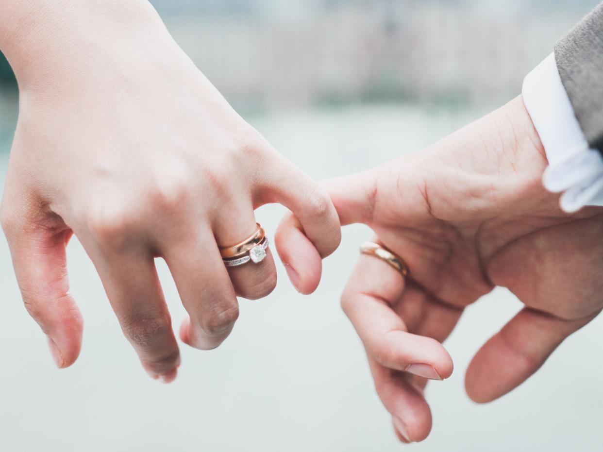 A newly wed couple doing a pinky promise (Getty Images/iStockphoto)