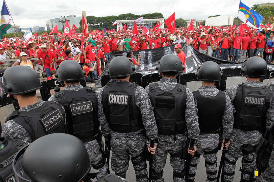 A shock battalion of the Military Police mounts barrier in front of the Planalto presidential palace during a March of the Landless Workers Movement in Brasilia, Brazil, Wednesday, Feb. 12, 2014. The Landless Workers Movement, one of the globe’s biggest agrarian reform movements called the protest to demand that the government hand over more unused land to impoverished farmers who have none of their own. (AP Photo/Eraldo Peres)
