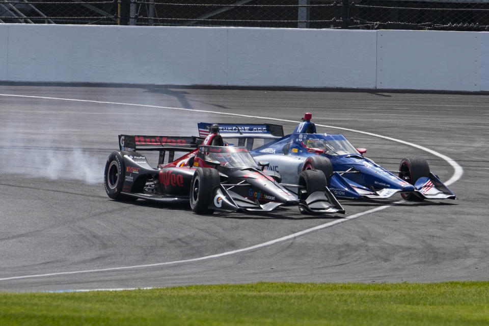 Christian Lundgaard, of Denmark, left, leads Alex Palou, of Spain, into the first turn on the start of the IndyCar auto race at Indianapolis Motor Speedway in Indianapolis, Saturday, May 13, 2023. (AP Photo/Michael Conroy)