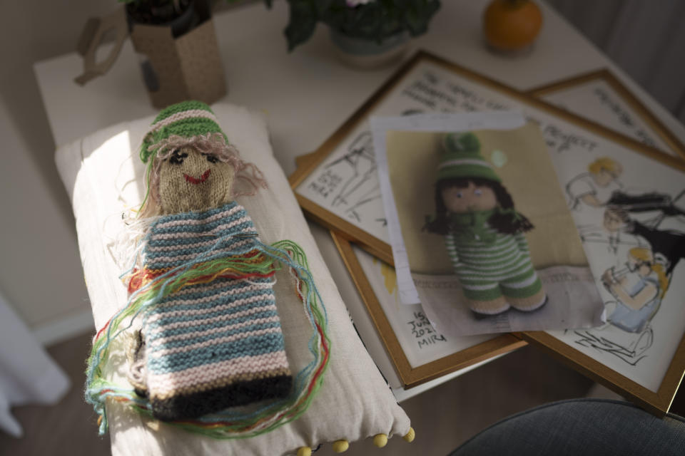 A doll that Tami Halevi, 86, is knitting lies on a table at the apartment where she is staying in Bat Yam, Israel, Friday, Feb. 9, 2024, after leaving her house in Kibbutz Nahal Oz. (AP Photo/Leo Correa)