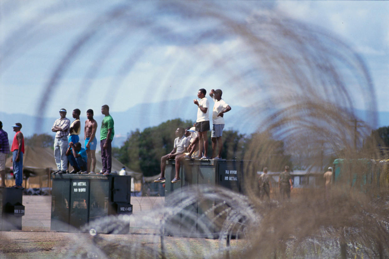 Haitian Refugees Waiting on Crates - Credit: Steve Starr/CORBIS/Corbis/Getty Images
