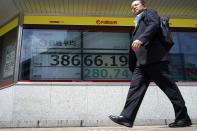 A person walks in front of an electronic stock board showing Japan's Nikkei 225 index at a securities firm Wednesday, May 22, 2024, in Tokyo. (AP Photo/Eugene Hoshiko)