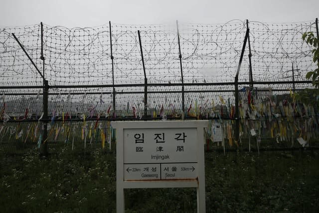 A directional sign showing the distance to North Korea’s Kaesong city and South Korea’s capital Seoul is seen near the wire fences decorated with ribbons written with messages wishing for the reunification of the two Koreas at the Imjingak Pavilion in Paju, South Korea (Lee Jin-man/AP)