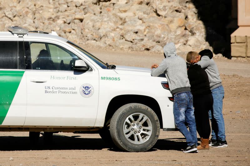 FILE PHOTO: Cuban migrants are detained by a U.S. Border Patrol agent as they turn themselves in to request asylum, after crossing into El Paso, Texas, U.S., as seen from Ciudad Juarez