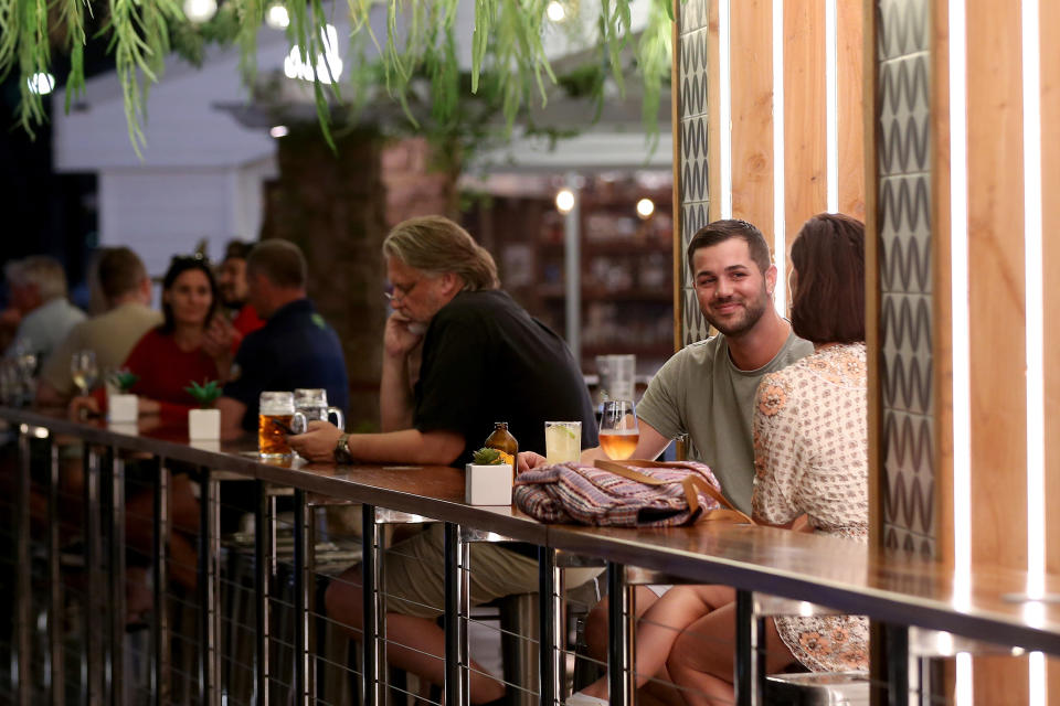 People drink beer at a high table at a pub.