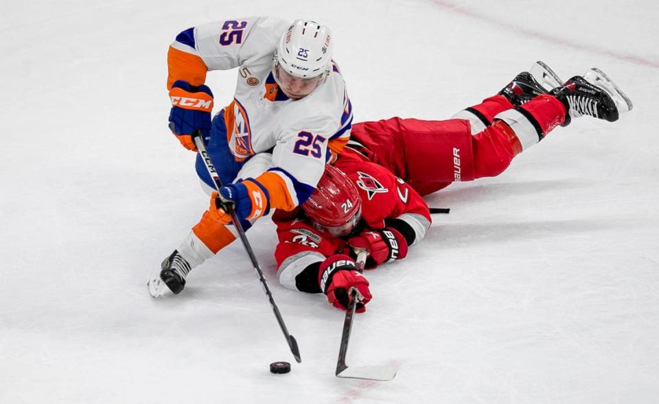 Carolina’s Hurricanes’ Seth Jarvis (24) goes under New York Islanders’ Sebastian Aho (25) as they battle for the puck in the third period of game one of their first round Stanley Cup series game on Monday, April 17, 2023 at PNC Arena in Raleigh, N.C.
