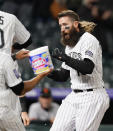 Colorado Rockies' Charlie Blackmon is welcomed by teammates at home plate affter Blackmon hit a three-run, walkoff home run of San Francisco Giants relief pitcher Camilo Doval in the seventh inning of game two of a baseball doubleheader Tuesday, May 4, 2021, in Denver. The Rockies won the nightcap by score of 8-6.(AP Photo/David Zalubowski)