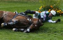 Australia's Clayton Fredericks lays near his horse Bendigo as he fell down while competing in the Eventing Cross Country equestrian event at the London 2012 Olympic Games in Greenwich Park, July 30, 2012.