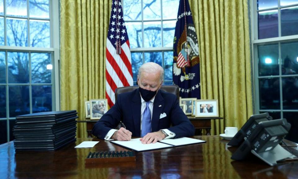 Joe Biden signs executive orders in the Oval Office after his inauguration.