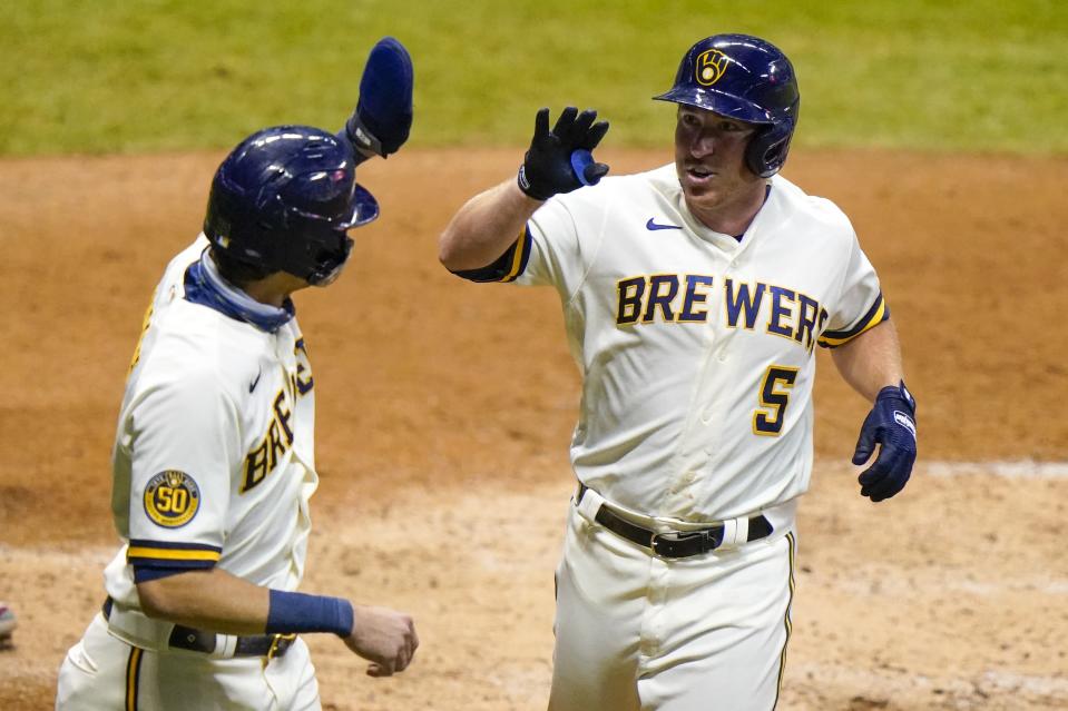 Milwaukee Brewers' Jedd Gyorko is congratulated by Christian Yelich after hitting a two-run home run during the eighth inning of a baseball game against the Minnesota Twins Tuesday, Aug. 11, 2020, in Milwaukee. (AP Photo/Morry Gash)