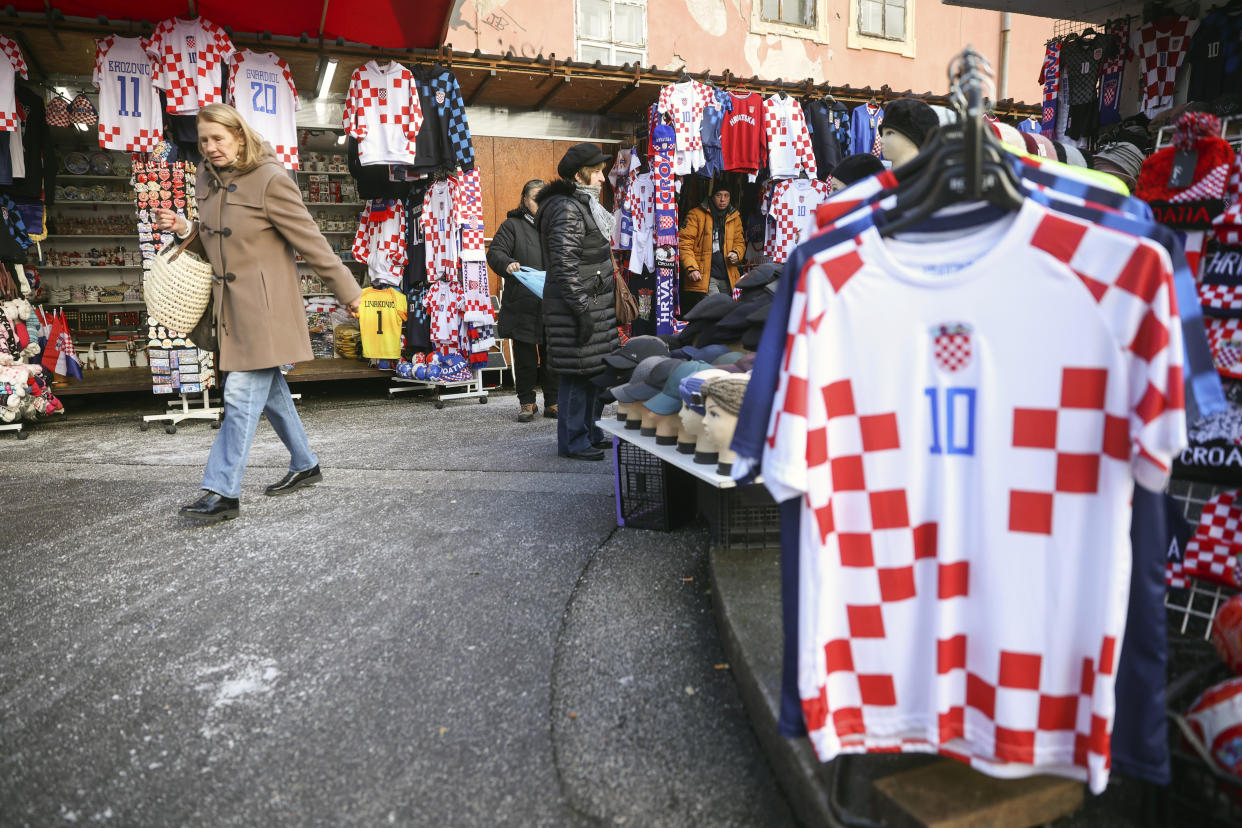 People walk among shops selling Croatian football jerseys and various fan props prior to the Qatar World Cup semi-final match between Croatia and Argentina, in Zagreb, Croatia, Tuesday, Dec. 13, 2022. (AP Photo/Armin Durgut)