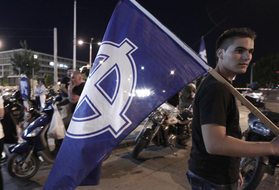 Supporters of the far right party of Golden Dawn celebrate the results of the elections outside their headquarters office in Thessaloniki, Greece Sunday, June 17, 2012. Official projections showed the Golden Dawn party returning to the 300-member parliament with 18 seats, just three fewer than it had won in an inconclusive election on May 6, when no party won enough votes to form a government amid a deep financial crisis that threatens Greece's place in the Eurozone and could hurt the global economy. The pro-bailout New Democracy party came in first Sunday in Greece's national election, and its leader has proposed forming a pro-euro coalition government. (AP Photo/Dimitri Messinis)
