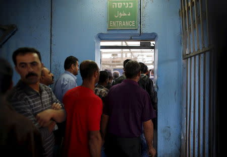 Palestinians wait to cross into Jerusalem at an Israeli checkpoint in the West Bank town of Bethlehem, in this July 7, 2013 file photo. REUTERS/Ammar Awad/Files