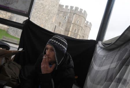 Stuart, a homeless man, sits under a bus shelter where he sleeps opposite Windsor Castle in Windsor, Britain, January 4, 2018. REUTERS/Toby Melville