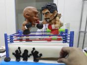 A cake decorator places details on a two-layer cake featuring fondant caricatures of boxers Manny Pacquiao (R) of the Philippines and Floyd Mayweather of the U.S. inside a boxing ring, as shown to the media, at a bakery in Manila, Philippines May 1, 2015. From air-conditioned corporate boardrooms to steamy public gymnasiums, Filipinos are counting down the hours to local boxing icon Manny Pacquiao's fight with undefeated American Floyd Mayweather Jr. in Las Vegas. The world welterweight championship bout, which is being called the "fight of the century," will bring the country to a standstill on Sunday and mark a rare period of unity for the poor Southeast Asian nation. Picture taken May 1, 2015. REUTERS/Romeo Ranoco