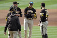 San Diego Padres pitching coach Larry Rothschild, left, comes out to the mound to talk to catcher Victor Caratini, starting pitcher Joe Musgrove, third baseman Manny Machado, second from right, and first baseman Eric Hosmer, right, after the Los Angeles Dodgers score a run during the second inning of a baseball game in Los Angeles, Sunday, April 25, 2021. (AP Photo/Alex Gallardo)