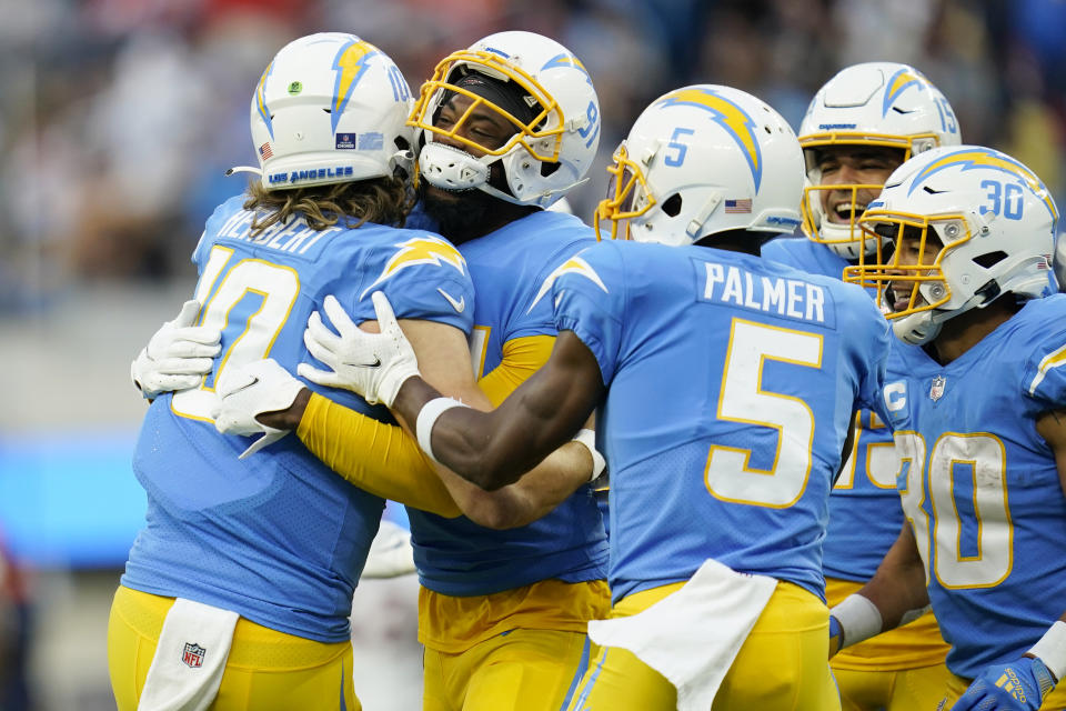 Los Angeles Chargers quarterback Justin Herbert (10) hugs wide receiver Mike Williams after Williams' touchdown catch during the second half of an NFL football game against the Denver Broncos Sunday, Jan. 2, 2022, in Inglewood, Calif. (AP Photo/Ashley Landis)