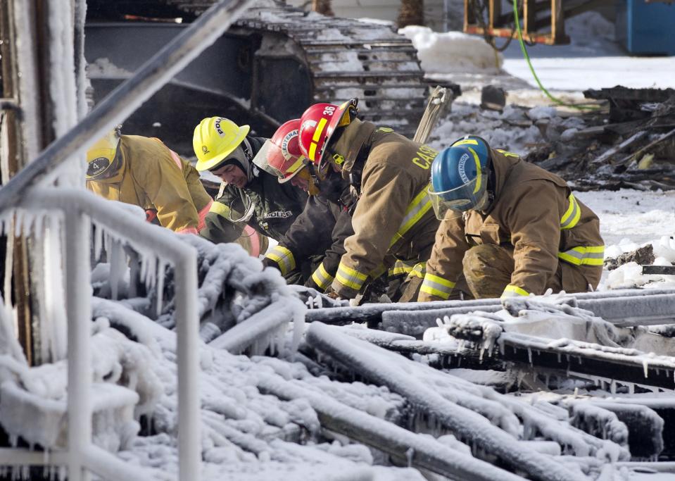 Rescue personnel search through the icy rubble of a fire that destroyed a seniors' residence Friday, Jan. 24, 2014, in L'Isle-Verte, Quebec. Five people are confirmed dead and 30 people are still missing, while with cause of Thursday morning's blaze is unclear police said. Authorities are using steam to melt the ice and to preserve any bodies that are buried. (AP Photo/The Canadian Press, Ryan Remiorz)