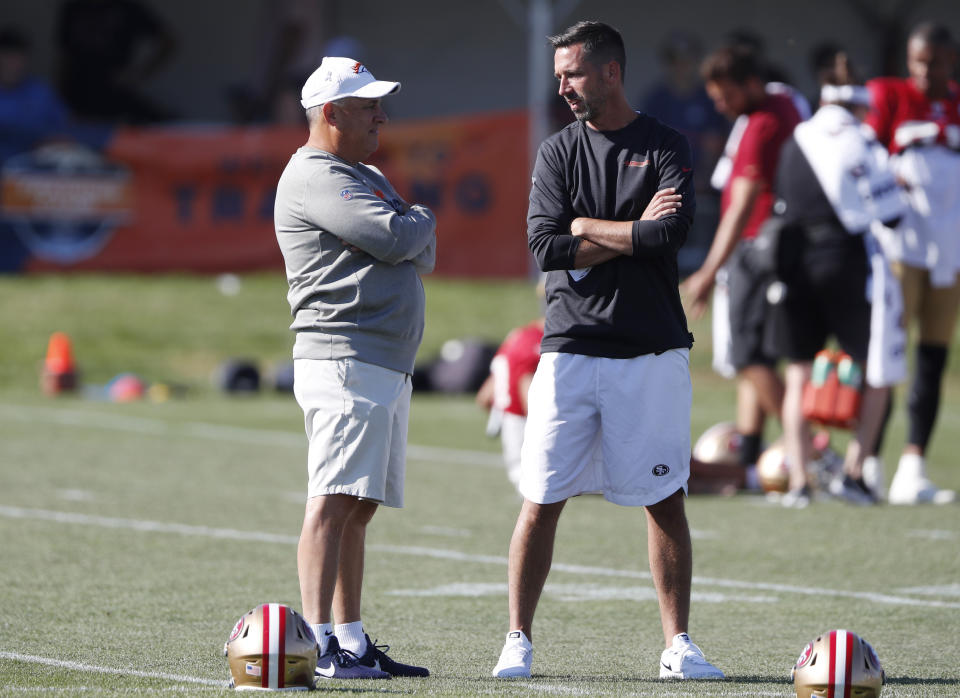 Denver Broncos head coach Vic Fangio, left, chats with San Francisco 49ers head coach Kyle Shanahan during a combined NFL training camp Saturday, Aug. 17, 2019, at the Broncos' headquarters in Englewood, Colo. (AP Photo/David Zalubowski)