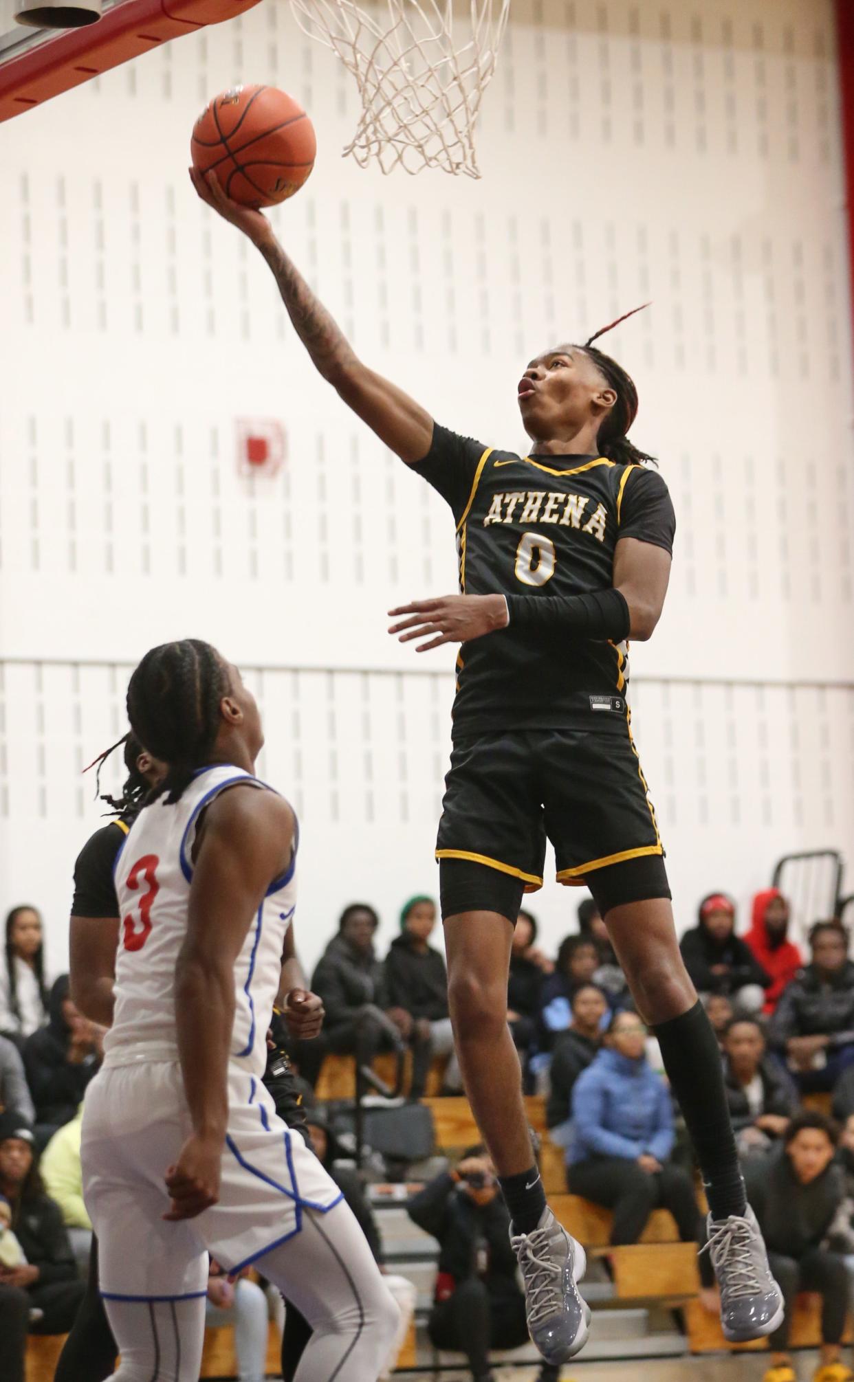 Athena's I'zick Reaves scores on a layup over Monroe's William McKinney.