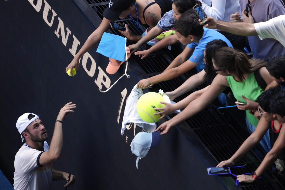 Tommy Paul of the U.S. signs autographs after defeating compatriot Ben Shelton in their quarterfinal match at the Australian Open tennis championship in Melbourne, Australia, Wednesday, Jan. 25, 2023. (AP Photo/Ng Han Guan)