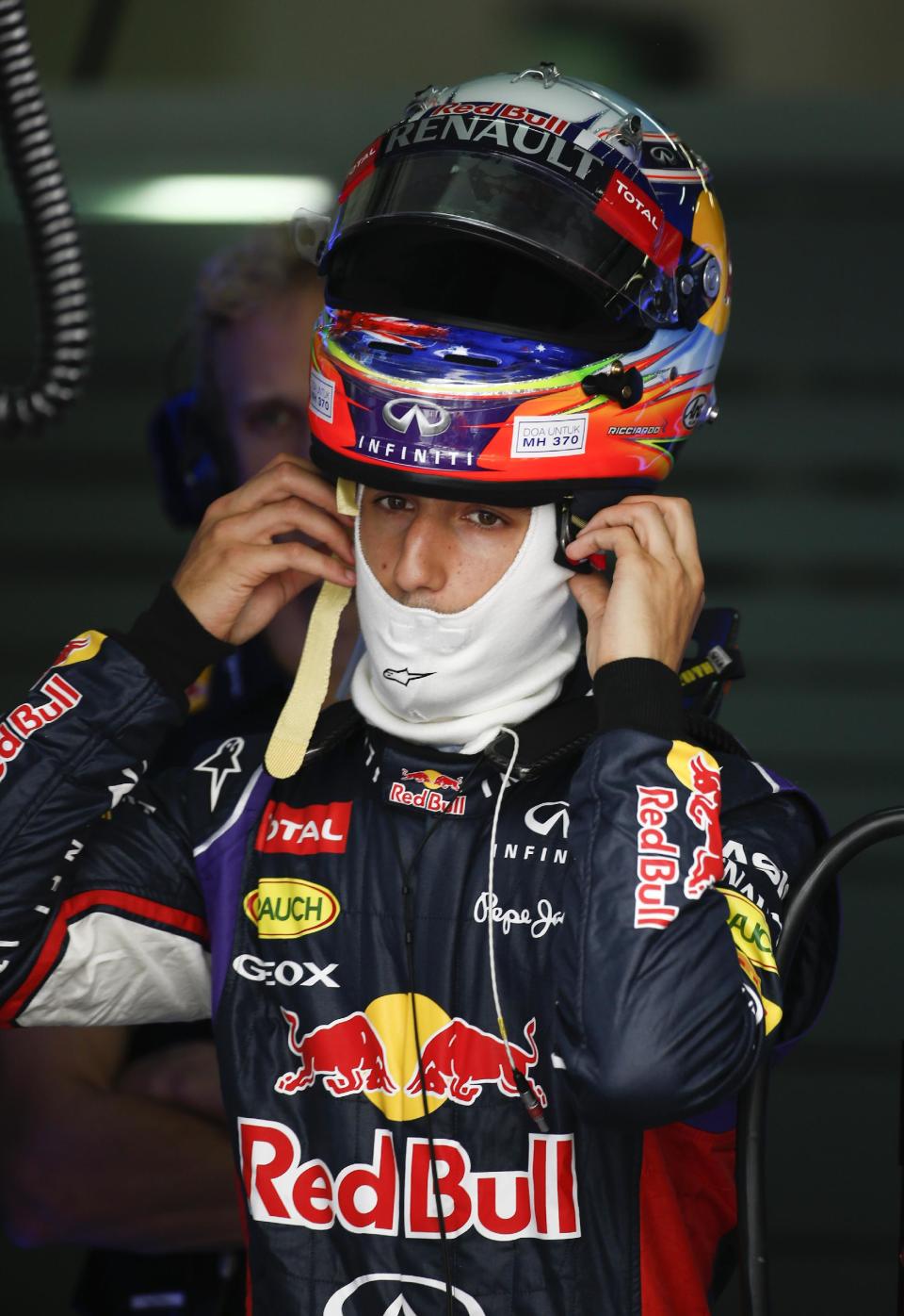 Red Bull Racing driver Daniel Ricciardo of Australia put on his helmet before the third practice session for the Malaysian Formula One Grand Prix at Sepang International Circuit in Sepang, Malaysia, Saturday, March 29, 2014. (AP Photo/Vincent Thian)