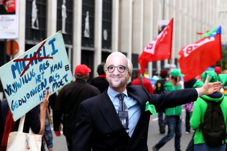 A man wears a mask depicting Belgian Prime Minister Charles Michel during a protest over the government's reforms and cost-cutting measures, in Brussels, Belgium September 29, 2016. REUTERS/Yves Herman