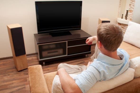 man lying on sofa watching tv...