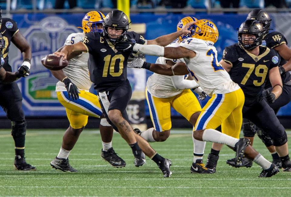 Wake Forest quarterback Sam Hartman, center, runs the ball against Pitt during the ACC Championship game at the Bank of America Stadium in Charlotte on Saturday December 4, 2021. Hartman was harassed the entire game and ended up throwing four interceptions in Pitt’s 45-21 win.