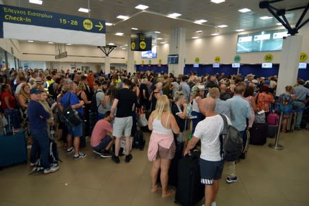 Passengers wait for their flights inside the Ioannis Kapodistrias International Airport after Thomas Cook, the world's oldest travel firm collapsed