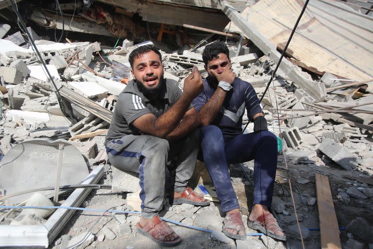 Los palestinos lloran mientras se sientan sobre los escombros de un edificio en el campo de refugiados de Shati en la Ciudad de Gaza el 6 de noviembre de 2023.