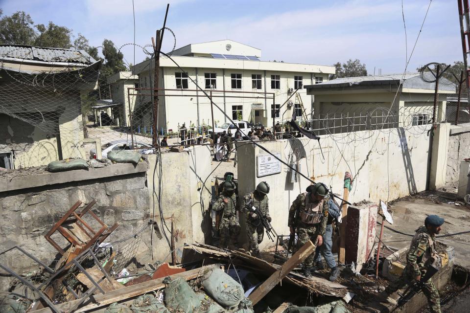 Afghan Army soldiers and police search through a police station after the Taliban staged a multi-pronged attack on a police station in Jalalabad, eastern Afghanistan, Thursday, March 20, 2014. Taliban insurgents staged the attack, using a suicide bomber and gunmen to lay siege to the station, government officials said. Two remotely detonated bombs also exploded nearby. (AP Photo/Rahmat Gul)