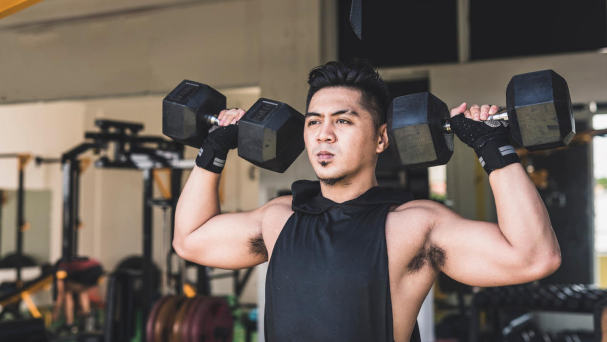  Man doing dumbbell shoulder press. 