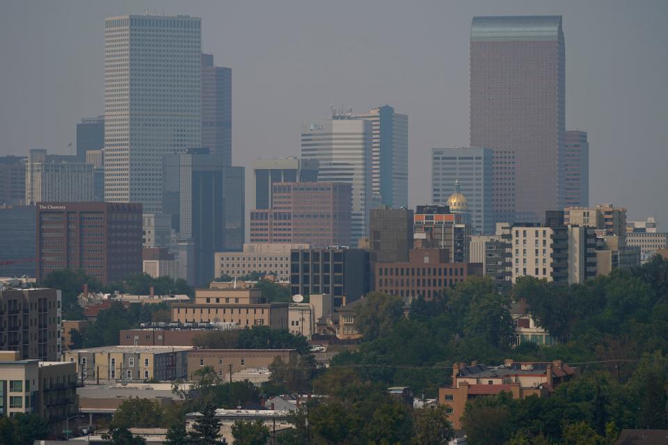 The calm before the storm: Smoke envelopes the downtown skyline as winds carry the smoky air from the Cameron Peak Fire burning in Colorado's High Country Monday, Sept. 7, 2020, in Denver. A winter storm was hitting the city on Tuesday, Sept. 8.