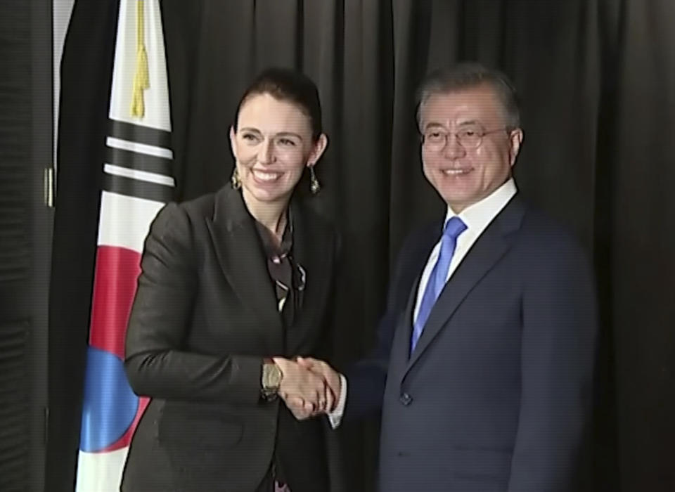 In this image made from a video, New Zealand's Prime Minister Jacinda Ardern, left, and South Korean President Moon Jae-in shake hands in Auckland, New Zealand Tuesday, Dec. 4, 2018. Ardern says New Zealand will soon allow smoother immigration procedures for visitors from South Korea and plans to improve pension portability between the two countries. (NZ POOL via AP)