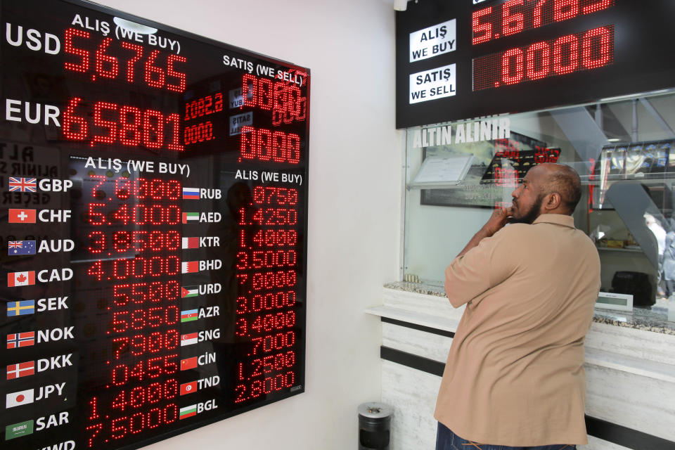 A man checks foreign currency exchange rates outside a currency exchange shop in an Istanbul's market, Friday, Aug. 10, 2018. A financial shockwave ripped through Turkey on Friday as its currency nosedived on concerns about its economic policies and a dispute with the U.S., which President Donald Trump stoked further with a promise to double tariffs on the NATO ally. . (AP Photo/Mucahid Yapici)