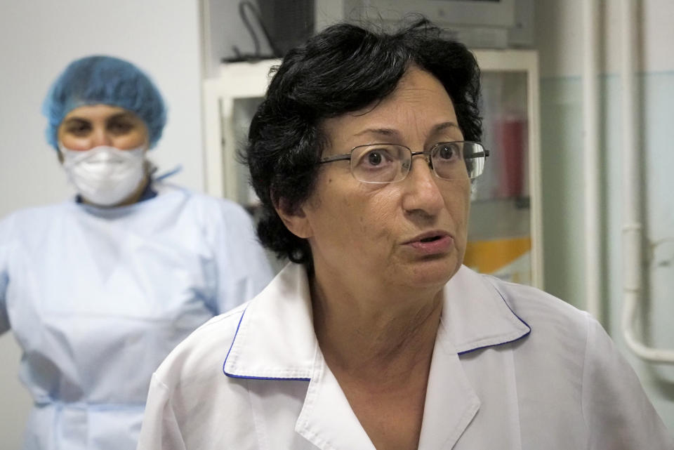 Malvina Badalyan, chief doctor, speaks to a patient at a clinic at the separatist region of Nagorno-Karabakh, Tuesday, Oct. 20, 2020. At Stepanakert's clinic for infectious diseases, coronavirus patients also have often had to go down to the basement to hide from shelling, chief doctor Malvina Badalyan said. (AP Photo)