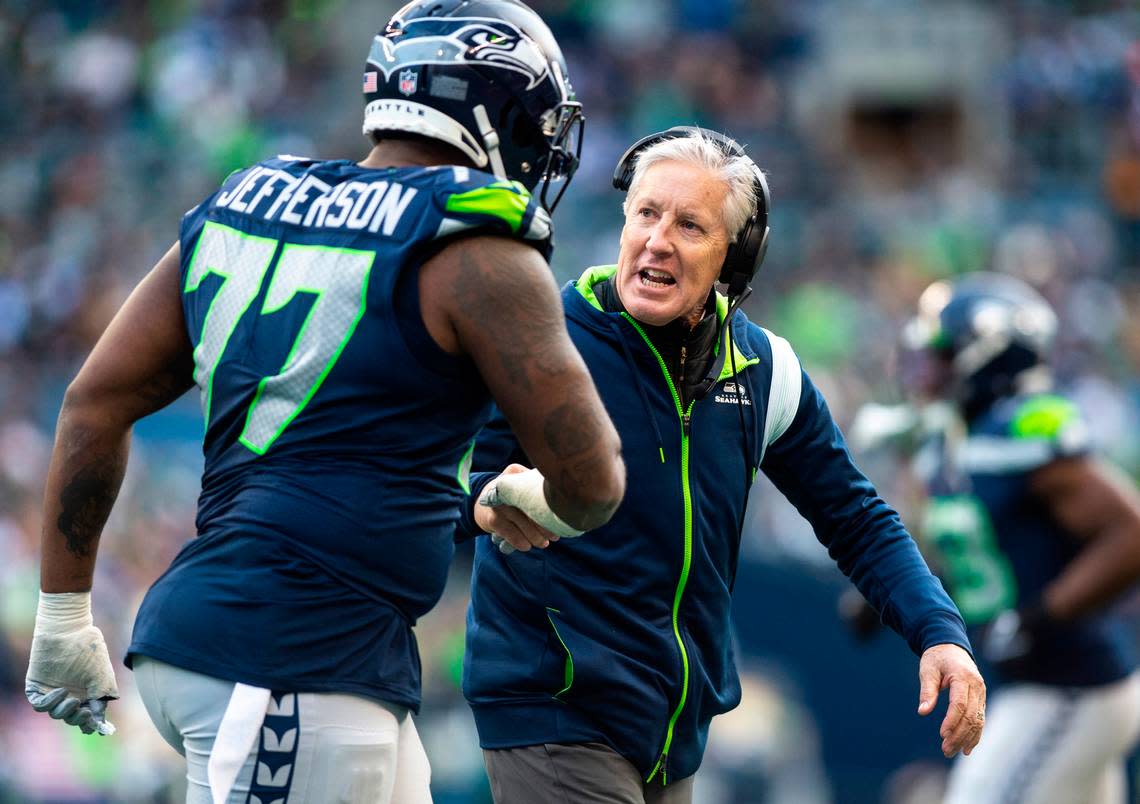 Seattle Seahawks head coach Pete Carroll shakes hands with Seattle Seahawks defensive tackle Quinton Jefferson (77) as they walk off the field during the third quarter of an NFL game against the New York Jets at Lumen Field in Seattle Wash. on Jan. 1, 2023. The Seahawks defeated the Jets 23-6.