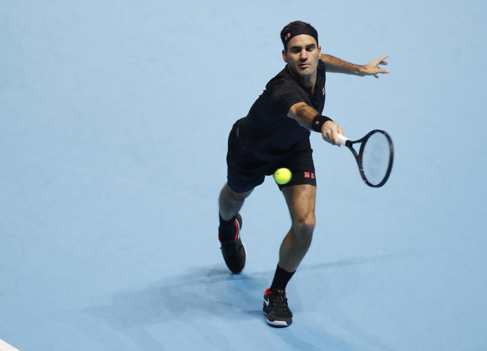 Switzerland's Roger Federer plays a return to Italy's Matteo Berrettini during their ATP World Tour Finals singles tennis match at the O2 Arena in London, Tuesday, Nov. 12, 2019. (AP Photo/Alastair Grant)