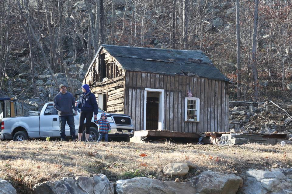 Owner Tucker Kelly, Cathy Finkel of the Green Pond History Association and Finkel's grandson beside a log cabin uncovered earlier this fall in Rockaway Township. "This is an amazing find," Finkel said of the cabin, which may date back to the 1820s. "It's history right in front of our eyes."
