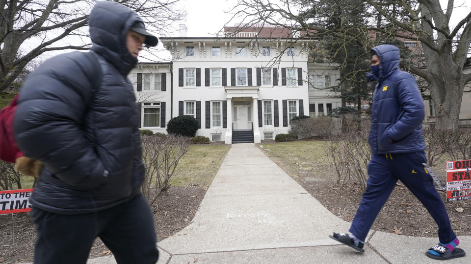 Students walk past the University of Michigan's Presidents House on campus in Ann Arbor, Mich., Thursday, Jan. 20, 2022. A financial payout for more than 1,000 people — mostly men — who say they were sexually assaulted by former University of Michigan sports doctor Robert Anderson is the latest multimillion-dollar settlement involving schools faced with sexual misconduct scandals. (AP Photo/Paul Sancya)